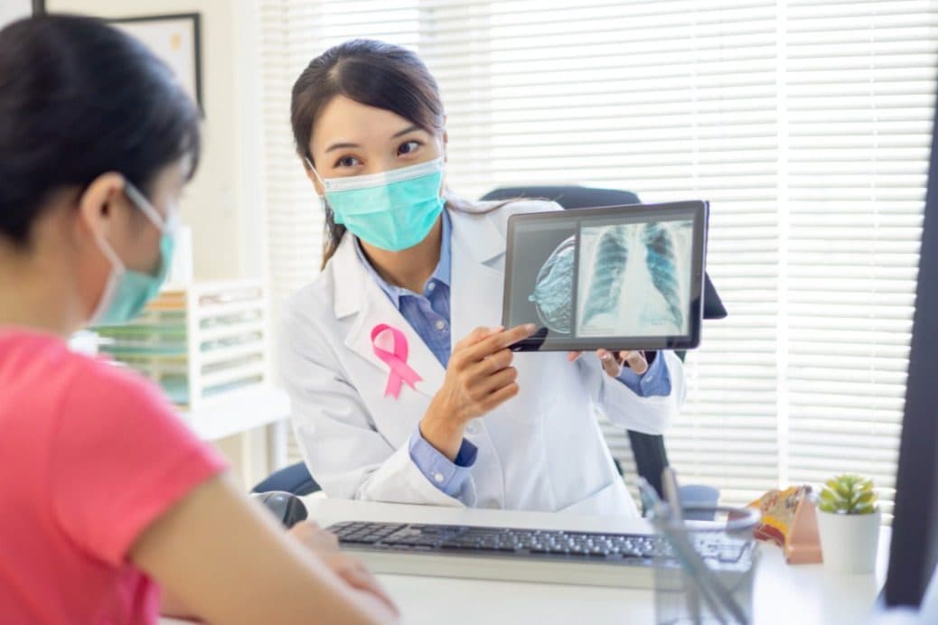 A clinician talking a patient through her breast images